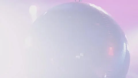 Shiny disco ball rotating in dark studio with pink lights and cinematic len.. Stock Footage 337389383