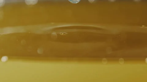 Shiny drop of sunflower or olive oil falls into a container of liquid Stock Footage 309951973