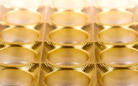 The shiny gold plastic background as texture of the empy candy box 스톡 사진