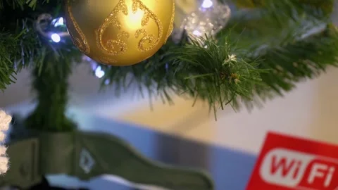 Shiny golden bauble on the artificial tree in office with wi-fi word. Gold color Stock Footage 138992463