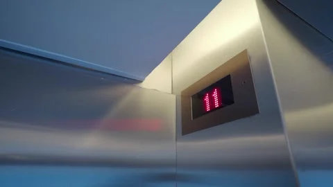 Shiny metallic elevator interior with display going down from thirteenth to.. Stock Footage 332208732