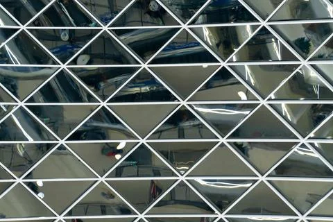 A shiny mirror surface made of triangular-shaped glass and long fluorescent l Fotos Stock