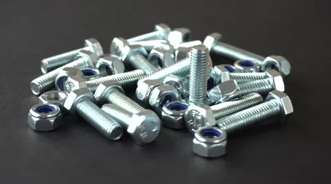 Shiny nuts and bolts rotating on a black background. Seamless loop. Prores 4K Stock Footage 66852151