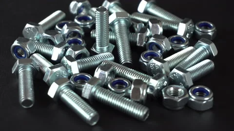 Shiny nuts and bolts rotating on a black background. Seamless loopable. Prores Stock Footage 67834016