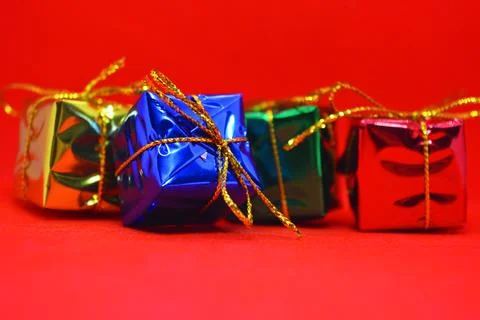Shiny packaging, boxes with festive and New Year's gifts tied with gold threads. Stock Photos