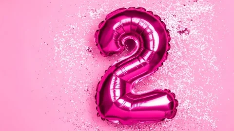 Shiny Pink Number Two Balloon Floating on Glittering Pink Background Stock Footage 333410480