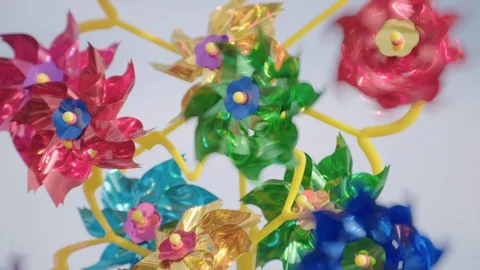 Shiny pinwheels spinning in the wind at the seaside Video stock 129690924