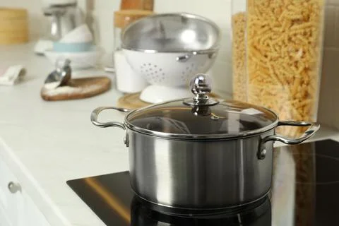 Shiny pot on electric stove in kitchen. Cooking utensil Stock Photos