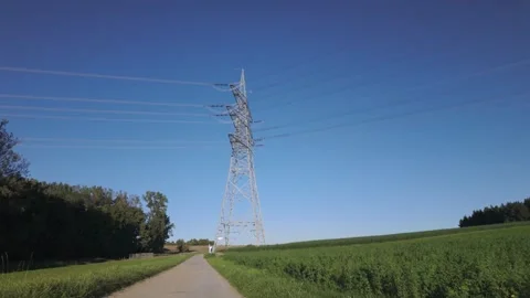 Shiny power cables between high-voltage towers against the clear blue sky Stock Footage 344796984