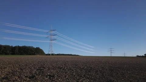 Shiny power cables between high-voltage towers against the clear blue sky Stock Footage 344797097