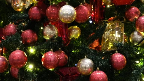 Shiny red and silver ornaments resting elegantly on vibrant greenery Stock Footage 326964585