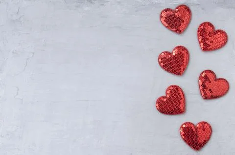 Shiny red hearts with sequins on a gray blue background. Template for design and Stock Photos
