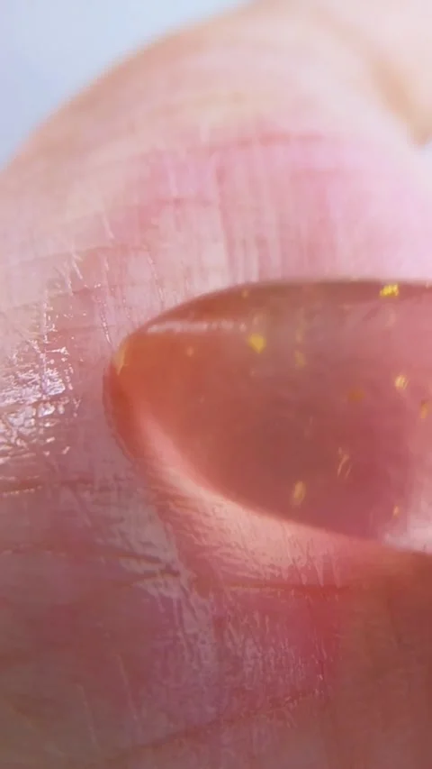 Shiny reddish palm gently rubbed with pink lip balm. Close up view. Lip car.. Stock Footage 339156423