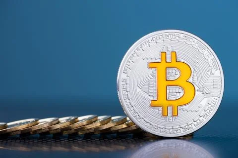 Shiny silver bitcoin with bit logo symbol and coins on dark blue background Foto stock