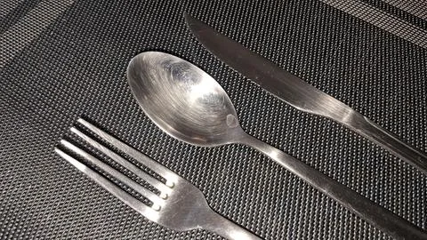 Shiny silver cutlery set including a fork spoon and knife Stock Photos