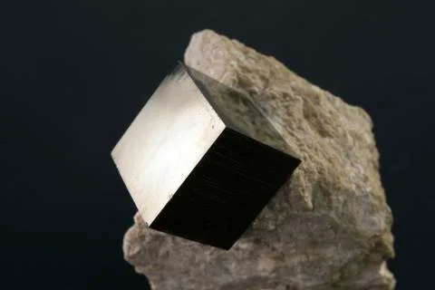 Shiny smooth regular shape pyrite cube on a dark background Stock Photos