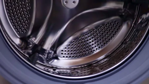 Shiny steel empty washing machine drum spinning close up Stock Footage 264092888
