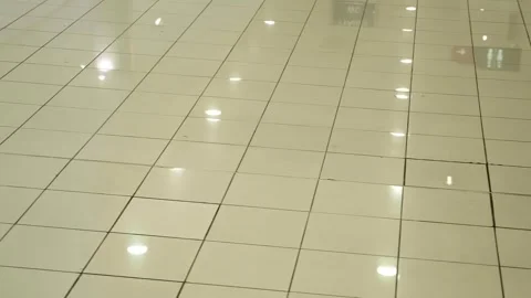 The shiny surface of the tiled floor reflecting the light from the ceiling lamps Video stock 333327114