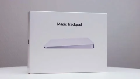 Shiny white package box of Mac magic trackpad on display stand with Apple Stock Footage 176446956