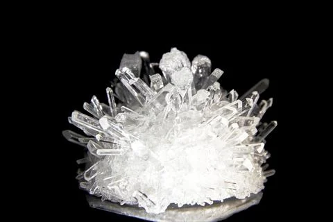 Shiny white sharp quartz crystal highlighted and isolated on black background Stock Photos