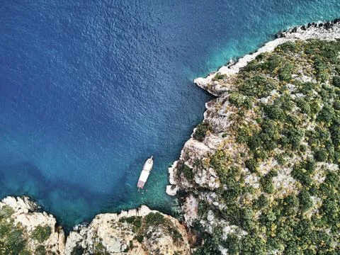 Ship from above aerial drone view. Blue deep water near the stony coast. people Stock Photos