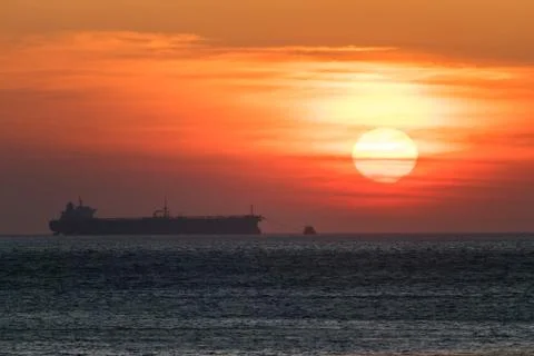 Ship on the background of an orange sunset Stockfoto's