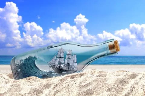 Ship in the bottle on a beach sand under cloudy blue sky Stock Photos