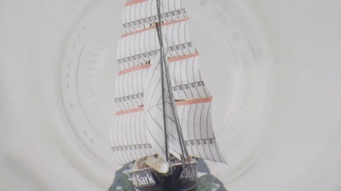 Ship in a bottle macro coming out the mouth of the bottle Stock Footage 123685598
