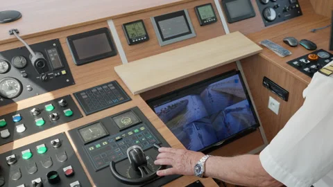 Ship captain navigating a vessel with modern bridge control console and joystick Stock Footage 342336586