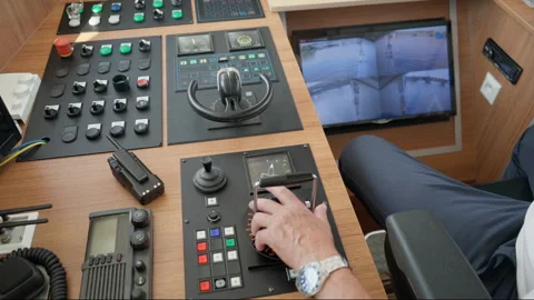 Ship captain operates engine throttle lever and bridge steering control console Stock Footage 342336548