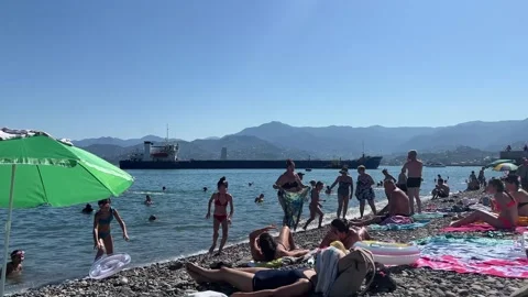 Ship with cargo containers is heading to port. People rests on sun loungers Stock-Footage 332808844