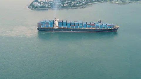 A ship carrying large numbers of containers reaching harbour an aerial view Stock Footage 100694748