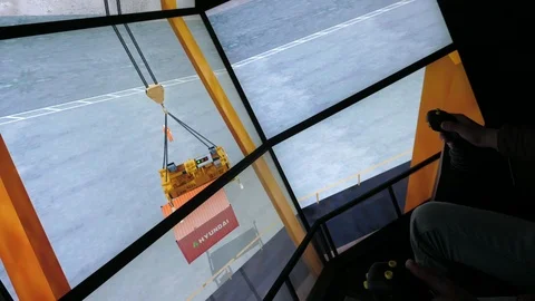 Ship crane simulator with a male hand controlling the load movement in cockpit Stock Footage 119968273