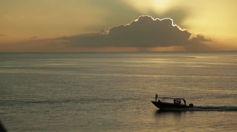 Ship crosses frame underneath a stunning cloudburst sunset - close up Vidéo 68100553