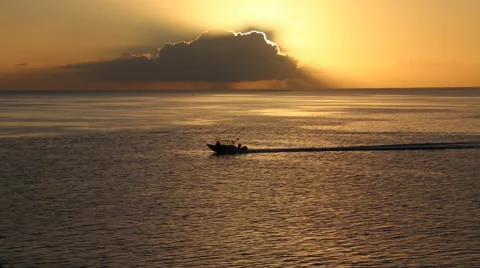 Ship crosses frame underneath a stunning cloudburst sunset - wide Vidéo 68100679