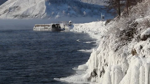 Ship dock covered with ice, icy shore pairs of winter Baikal lake in January Stock Footage 100751807