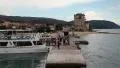 Ship docks to the shore near old tower in Ouranoupoli, Athos peninsula, Greece HD Footage
