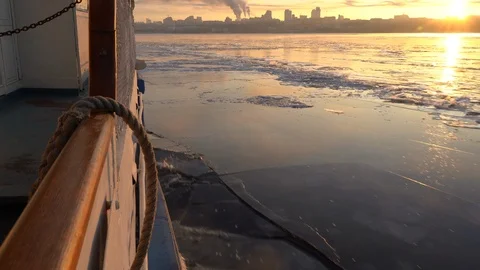 The ship floats on the ice-bound big river, breaking the thin ice. Stock Footage 121433728