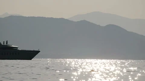 Ship go along the frame. On the background of rocks. Towards a small boat. Stock Footage 99833817