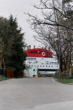 The ship is large and white with a red chimney. Stock Photos