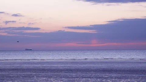 Ship lights go off as sun comes up - beach dawn Stock Footage 127732644