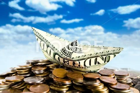 Ship made of dollar on top of coins on a sky background Stock Photos