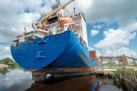 Ship moored at pier under loading. View from the aft stern prow. Stock Photos