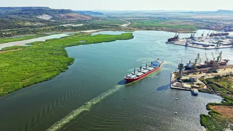 Ship moves along river near port with cranes and industrial area in the Stock Footage 341032978