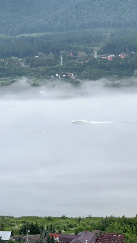 The ship is moving along a river shrouded in fog. Vertical 4K footage Stock Footage 340958254