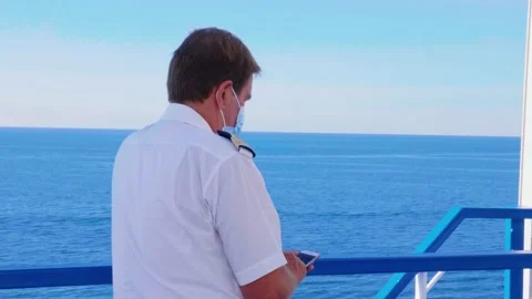Ship officer with mask checking his phone onboard. Officer on Ferry boat Stock Footage 139625265