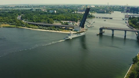 The ship passes under the drawbridge. the ship sails along the river. aerial Stock Footage 144672610