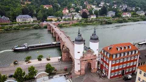 A ship passes under the Old Charles Bridge on the Neckar River in Heidelberg 4k Stock Footage 245970956