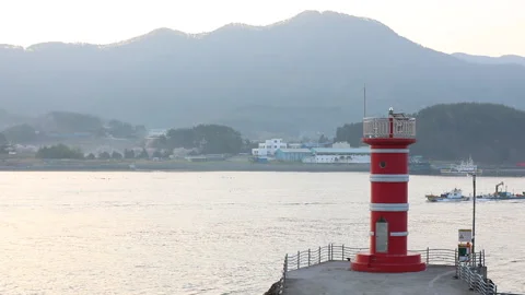 A ship passing by a red lighthouse Stock Footage 178874793