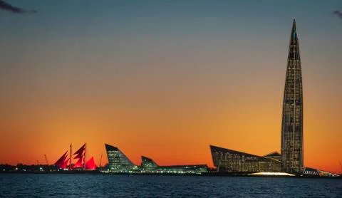A ship with red sails at sunset on the background of a beautiful city and a Stock Photos